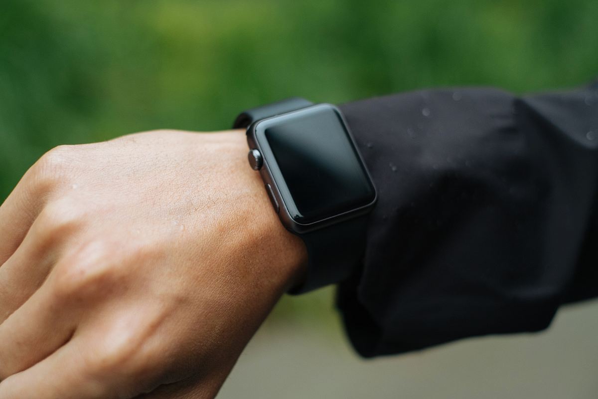 person wearing space gray Apple Watch turned off